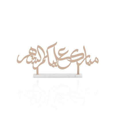Steel decor text written "Mubarak alaikum al shahar" with white color marble base