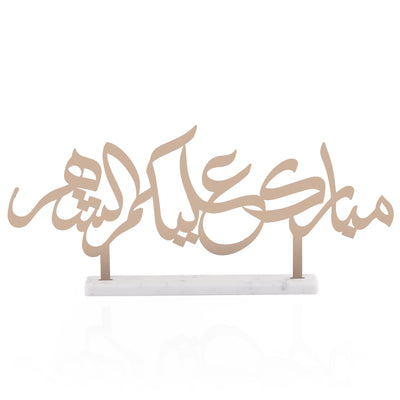 Steel decor text written "Mubarak alaikum al shahar" with white color marble base