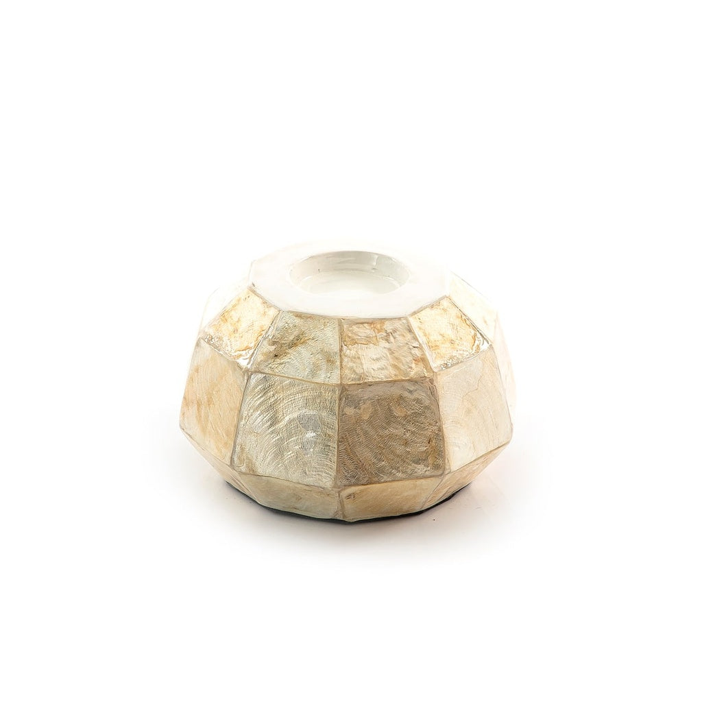 A faceted, geometric candle holder or vase made of natural mother-of-pearl shell pieces, featuring a white wax insert at the top, set against a plain white background.